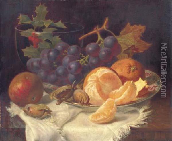 An Apple, Black Grapes, Two 
Oranges And Cob Nuts On Oriental Plate,with Holly In A Glass Vase, On A 
Wooden Table Oil Painting - Eloise Harriet Stannard