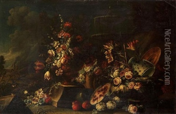 Carnations, Tulips, Peonies In An Urn With Other Flowers, A Melon, Pomegranates And A Blue And White Pottery Vase Before A Fountain In A Landscape Oil Painting - Giuseppe Lavagna