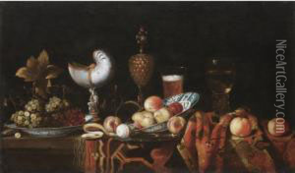 Still Life With Pears, Apples, 
Grapes In A Ceramic Bowl, A Partly Peeled Lemon, A Nautilus Cup, A 
Roemer And A Beer Glass, All Arranged On A Table Partly Draped With A 
Carpet Oil Painting - Johann Georg (also Hintz, Hainz, Heintz) Hinz